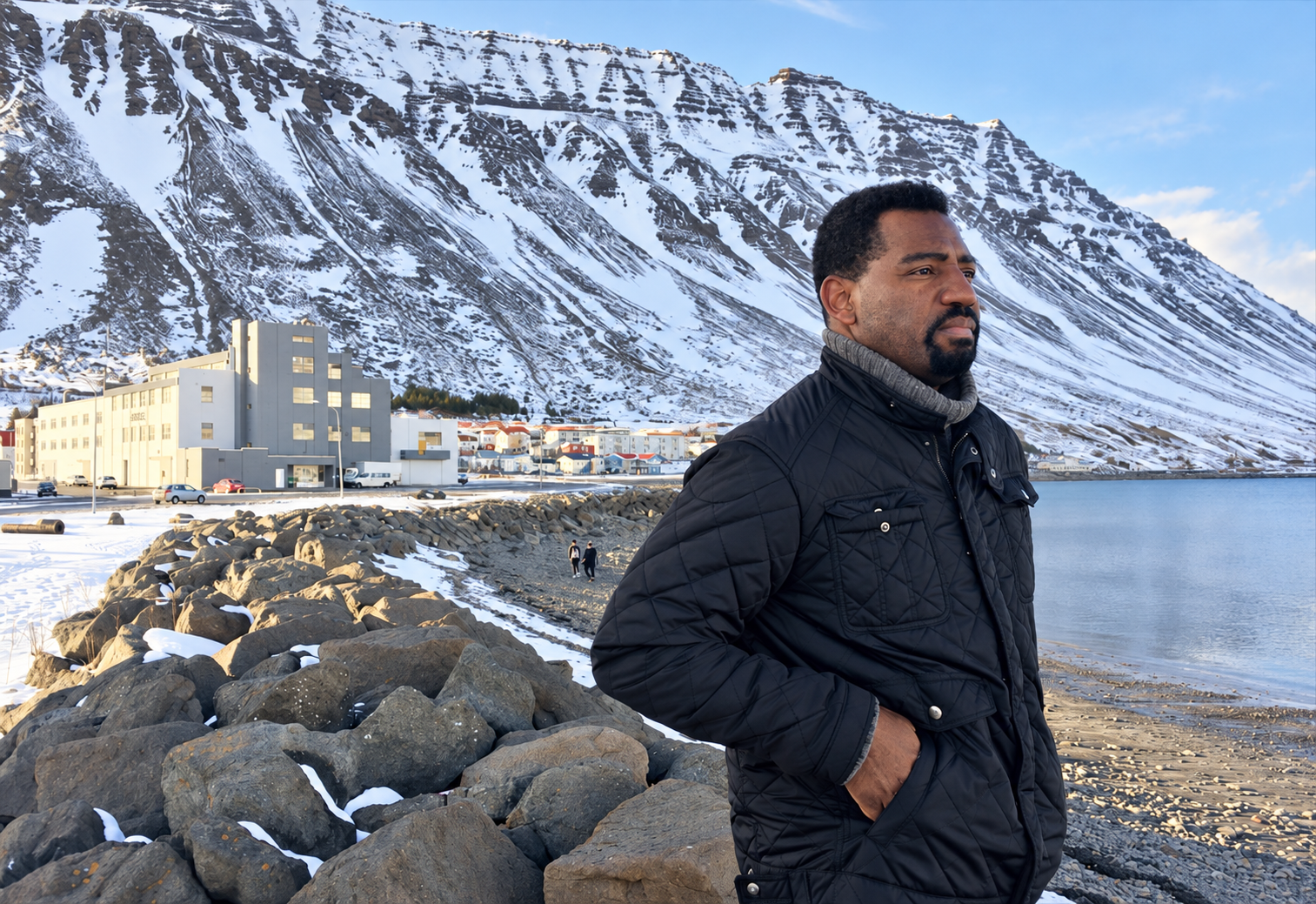 Aspen Powers on the coast of Iceland, with snow-covered mountains behind him
