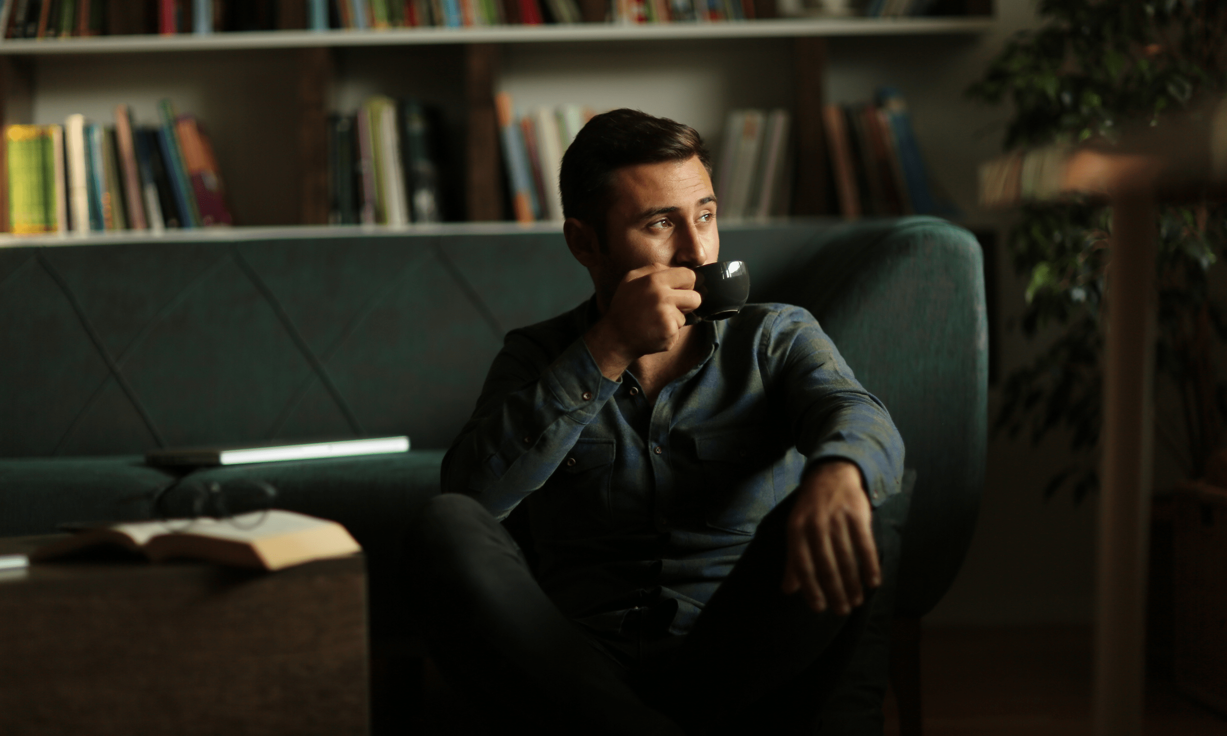 A man enjoying coffee in a softly lit lounge